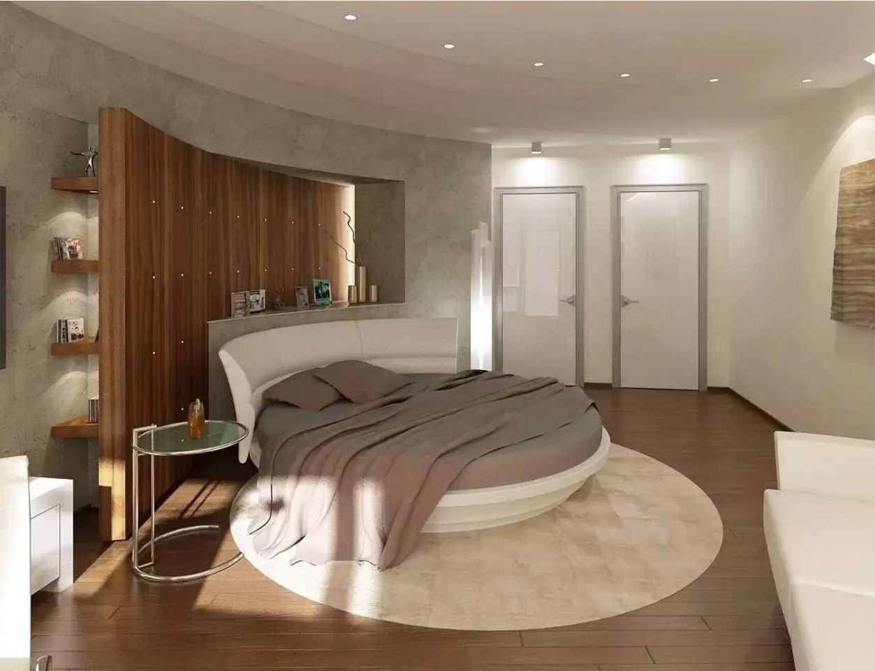 تخت خواب گرد سفید که برای ایجاد هارمونی در دکور اتاق، از فرش و پاتختی دایره ای در کنار آن استفاده شده است